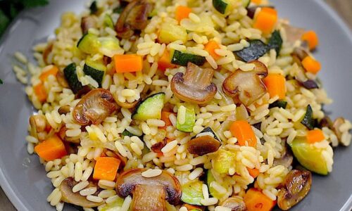 Reis mit Pilzen und Zucchini in einer Pfanne. Ein einfaches und leckeres Rezept.